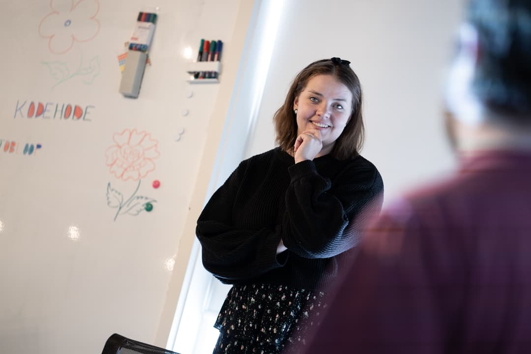 En av Kodehodes veiledere som underviser foran tavlen