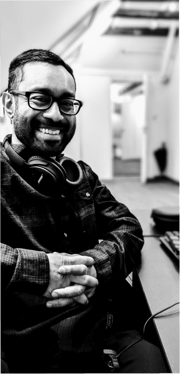 Svart-hvitt bilde av en student på Kodehode som smiler mot kamera